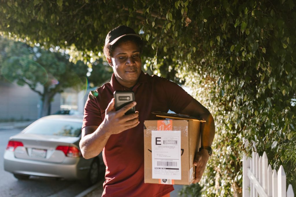 Courier delivering a package in a sunny urban neighbourhood